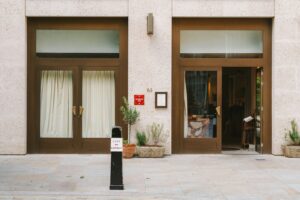 A building with two doors and a sign in front of it
