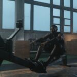 Un homme pratique le rowing sur un appareil dans une salle lumineuse