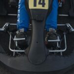 Pédales de frein d'un kart vues de dessus avec volant et numéro 14 visible