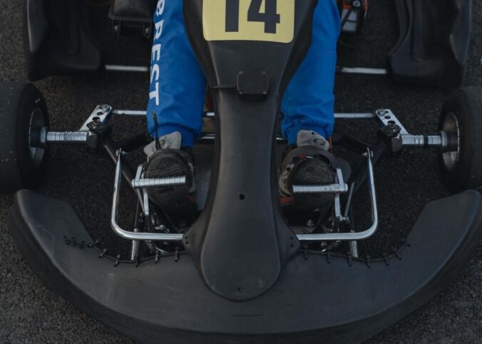 Pédales de frein d'un kart vues de dessus avec volant et numéro 14 visible