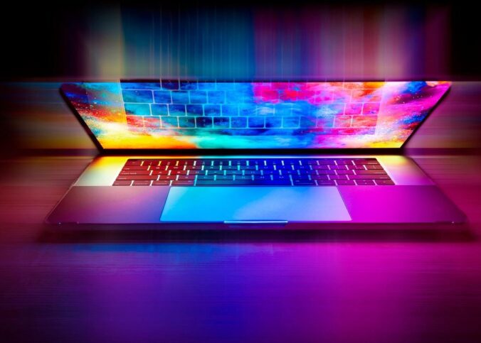 Un ordinateur portable ouvert avec écran arc-en-ciel et clavier rétroéclairé