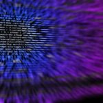 Écran d'ordinateur flou affichant du code informatique en arrière-plan violet