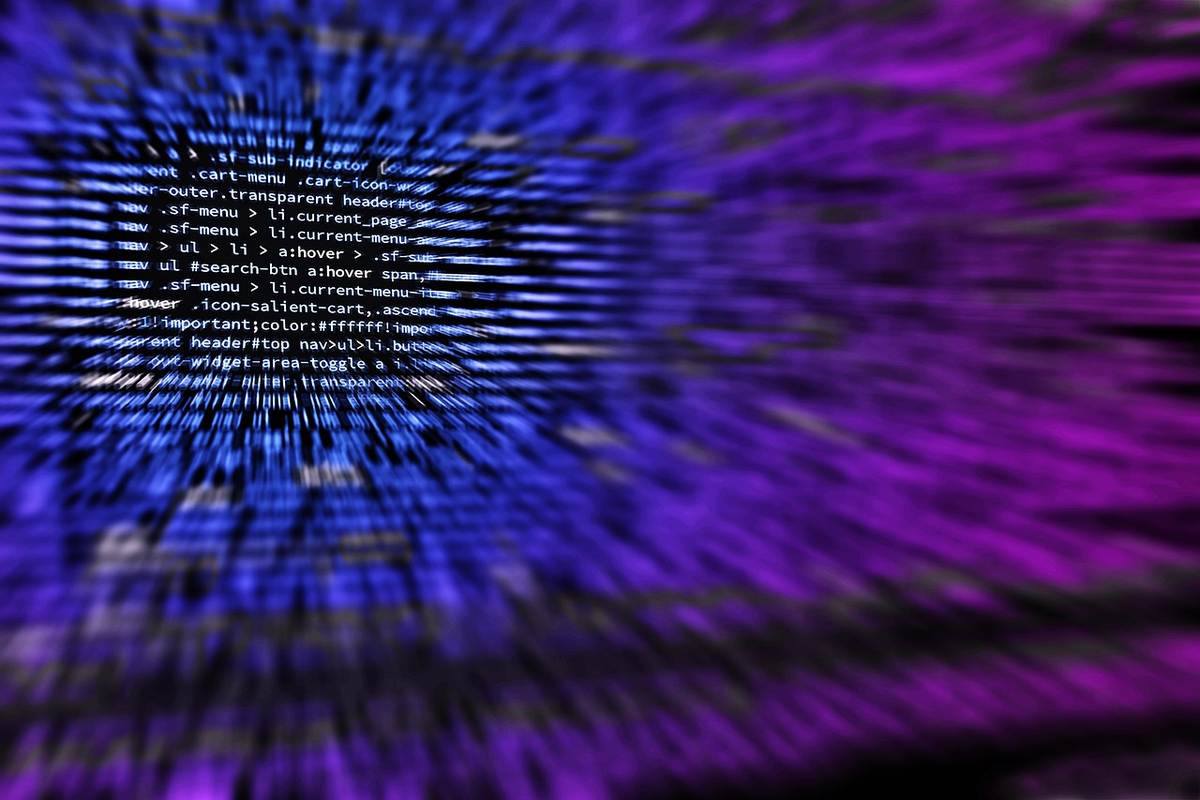 Écran d'ordinateur flou affichant du code informatique en arrière-plan violet