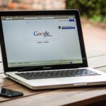 Un ordinateur portable affiche la page Google sur une table en bois