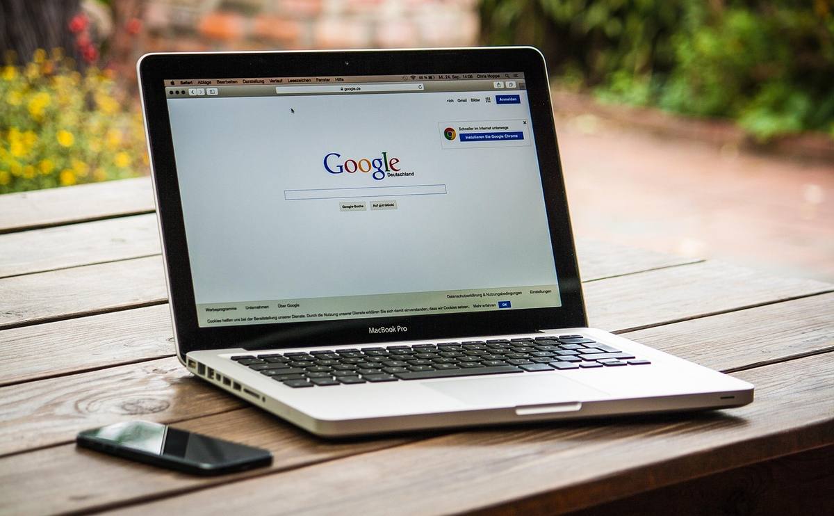 Un ordinateur portable affiche la page Google sur une table en bois